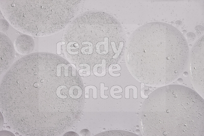 لقطات مقربة لفقاعات من الزيت على سطح الماء باللون الرمادي