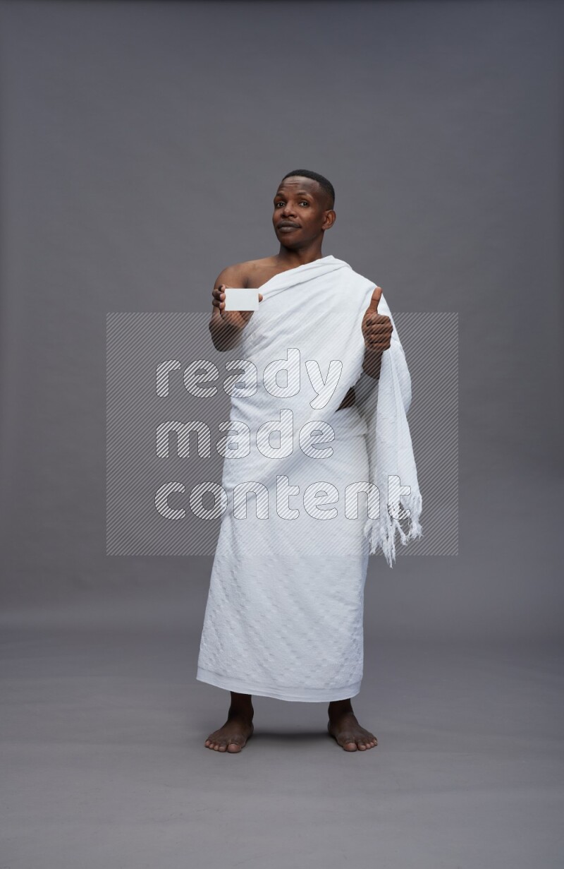 A man wearing Ehram Standing holding ATM card on gray background