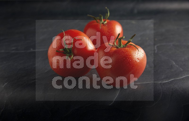 45 degree roma tomato on a textured black slate background