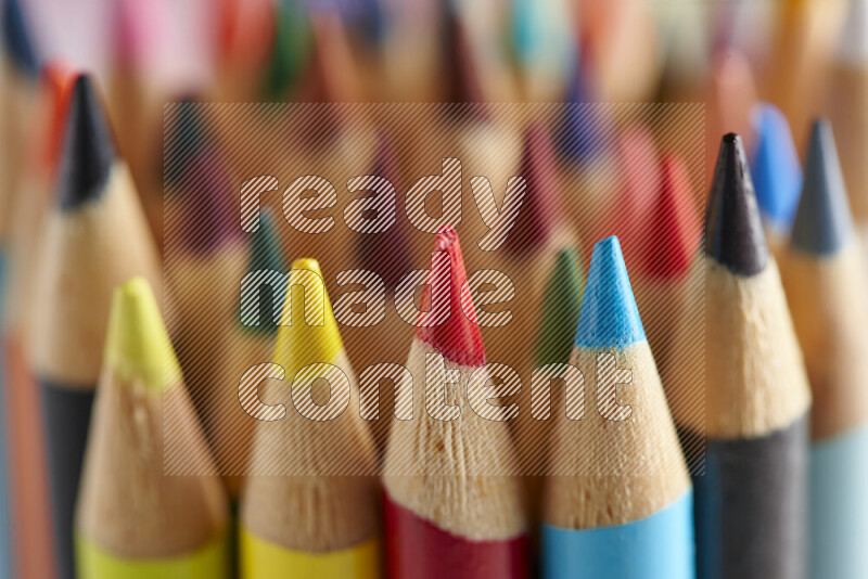The image captures a close-up of sharpened colored pencils on multicolored background