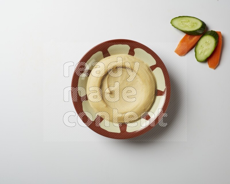 Plain hummus in a traditional plate on a white background