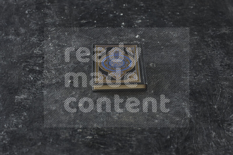 Quran with a prayer beads on textured black background