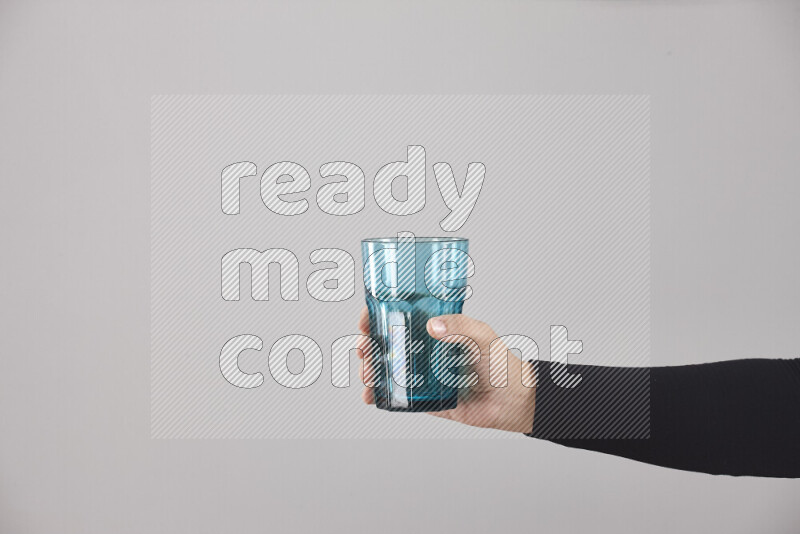 A woman in black abaya holding different glassware in different positions