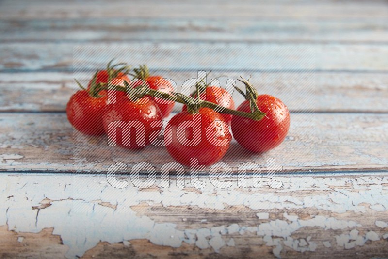 Red cherry tomato vein on a textured blue wooden background 45 degree