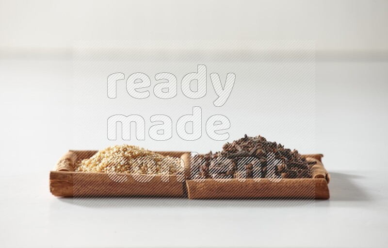 2 squares of cinnamon sticks full of cloves and sesame on white flooring