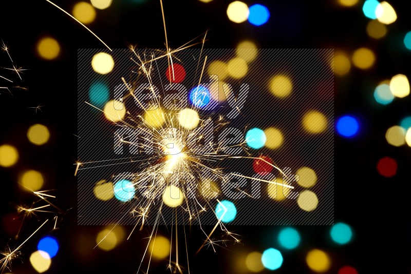 Sparkler candles with multicolored light bokeh background