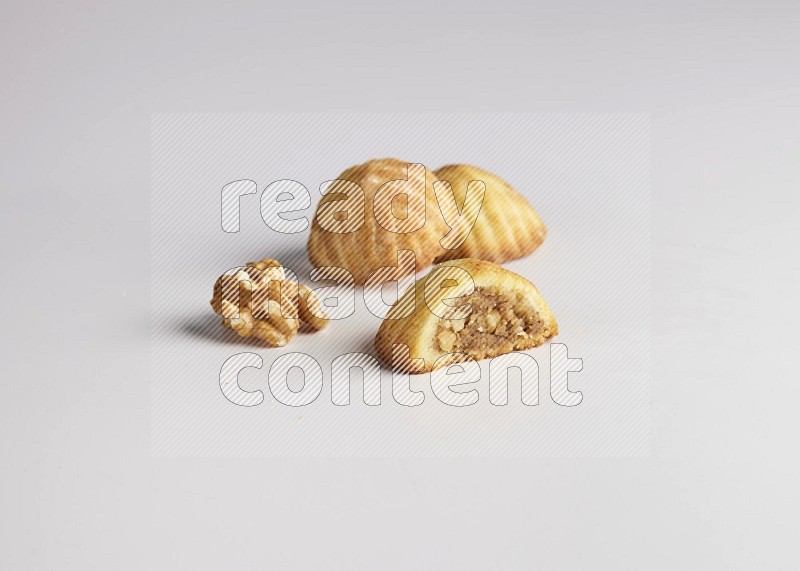 Three Pieces of Maamoul filled with walnut paste  one of them is cut direct on white background