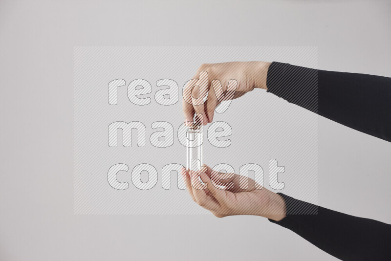 امرأة ترتدي عباءة سوداء تحمل أدوات زجاجية مختلفة في أوضاع متعددة