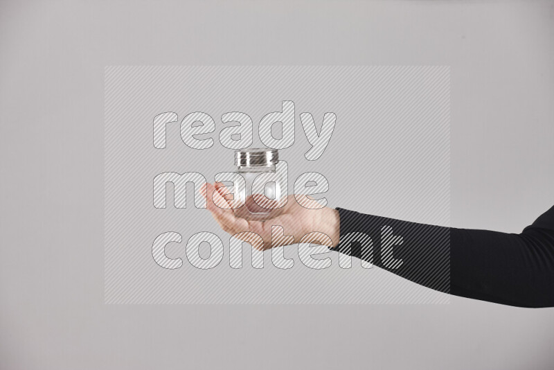 A woman in black abaya holding different glassware in different positions