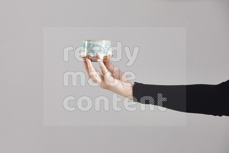 A woman in black abaya holding different pottery essentials in different positions