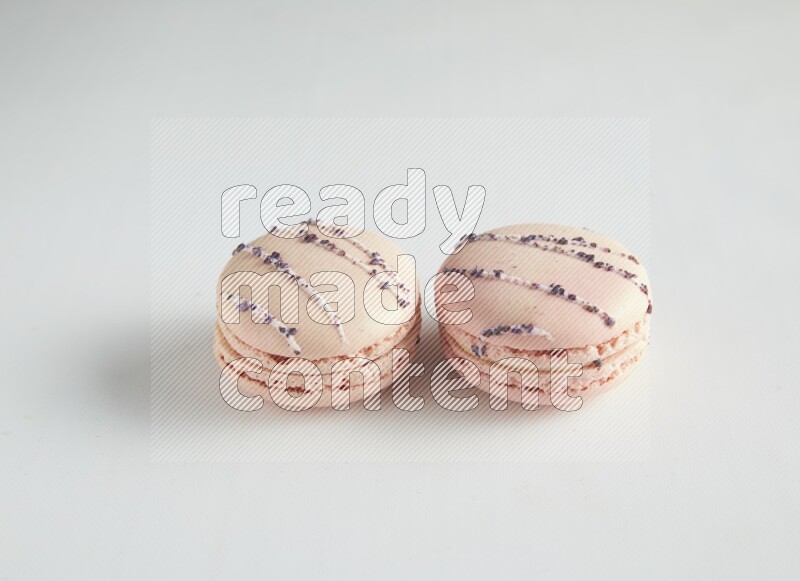 45º Shot of two pink orange blossom macarons on white background