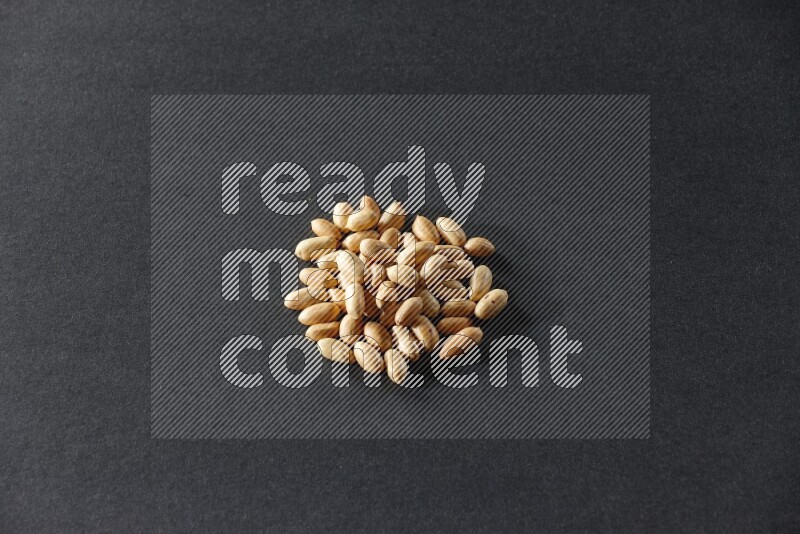 A bunch of peeled peanuts on a black background in different angles