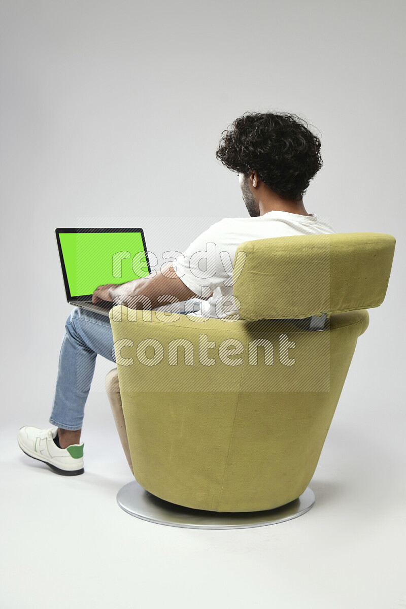 A man wearing casual sitting on a chair showing a laptop screen on white background