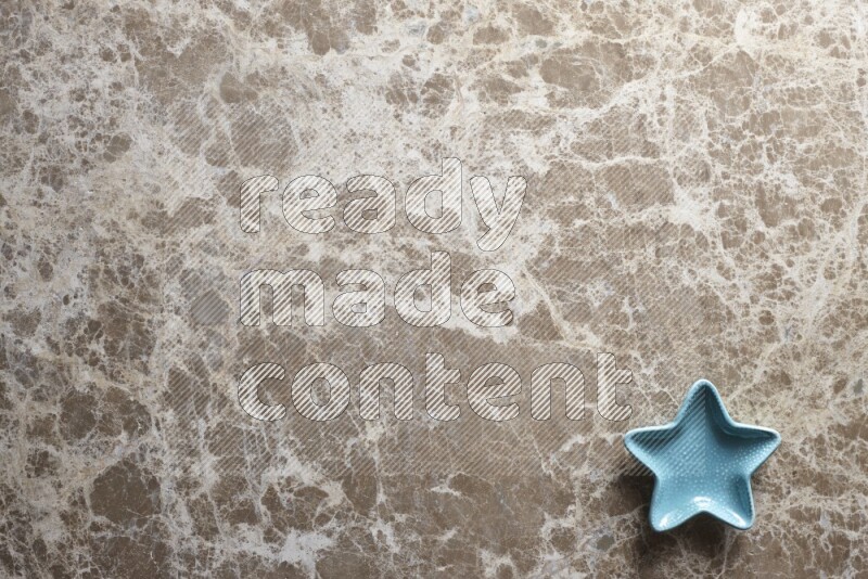 A colored pottery star plate on beige marble background