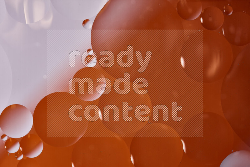 لقطات مقربة لفقاعات من الزيت على سطح الماء باللون الأبيض والبرتقالي