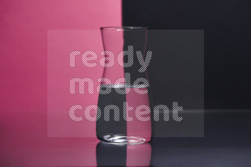 The image features a clear glassware filled with water, set against pink and black background