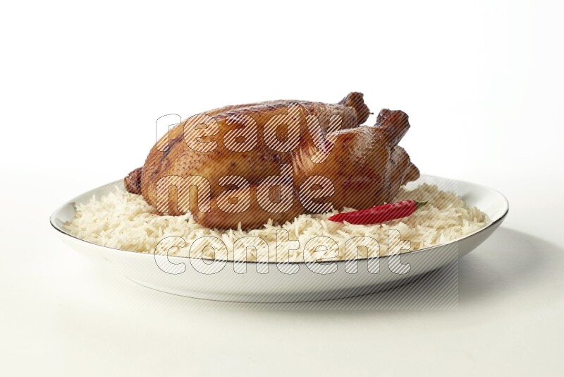 white  basmati Rice with  whole roasted chicken  on a white plate with a silver rim direct  on white background
