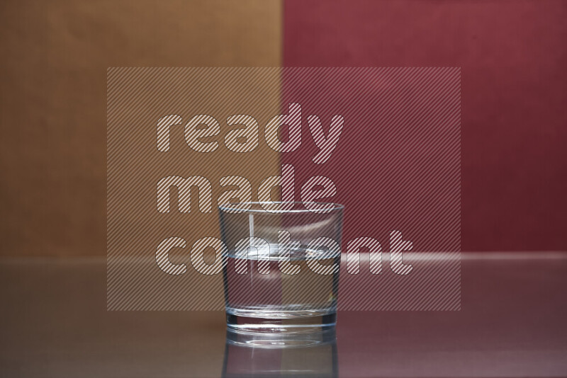 The image features a clear glassware filled with water, set against brown and dark red background