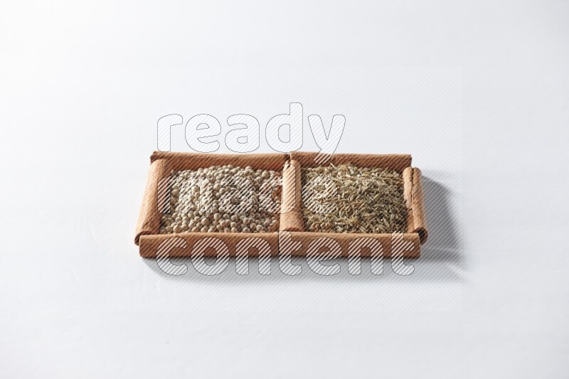 2 squares of cinnamon sticks full of white pepper and cumin on white flooring