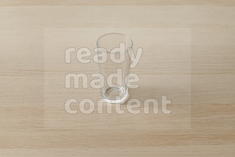 كوب فارغ زجاجي علي خلفية خشبية فاتحة