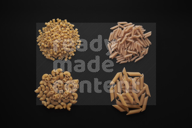 Different pasta types in bunches on black background