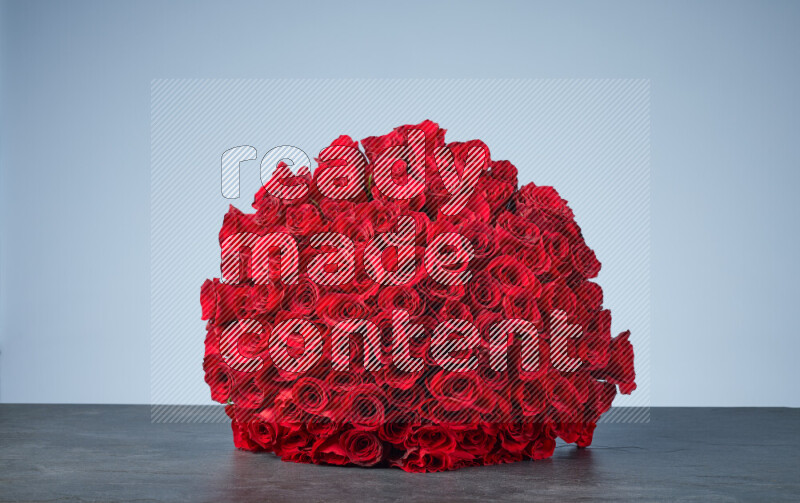 A sphere of vibrant red roses arranged tightly on black marble background