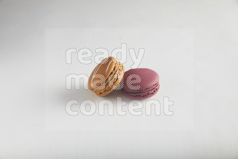 45º Shot of of two assorted Brown Irish Cream, and Red Cherry macarons on white background