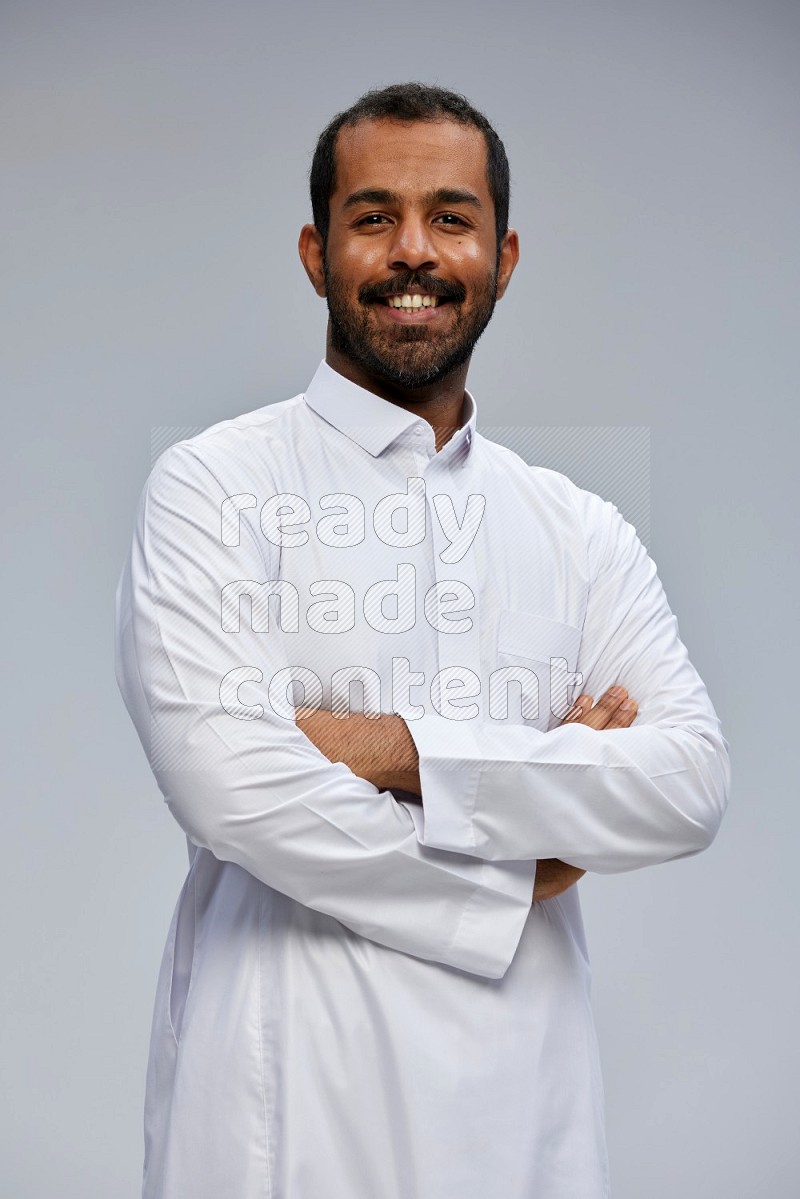 Saudi man wearing Thob standing with crossed arms on Gray background