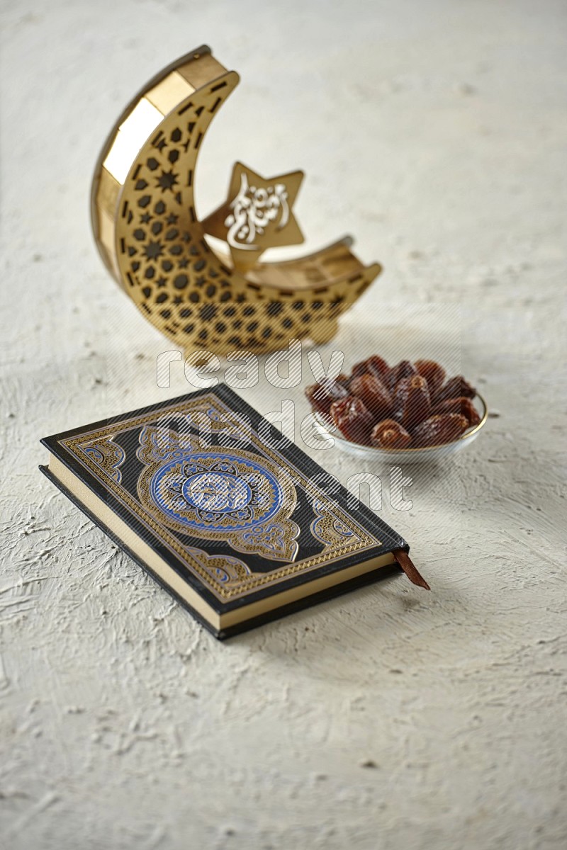 A wooden golden crescent lantern with different drinks, dates, nuts, prayer beads and quran on white background