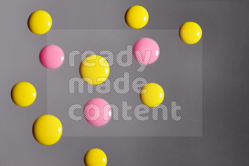 Close-ups of abstract pink and yellow paint droplets on the surface