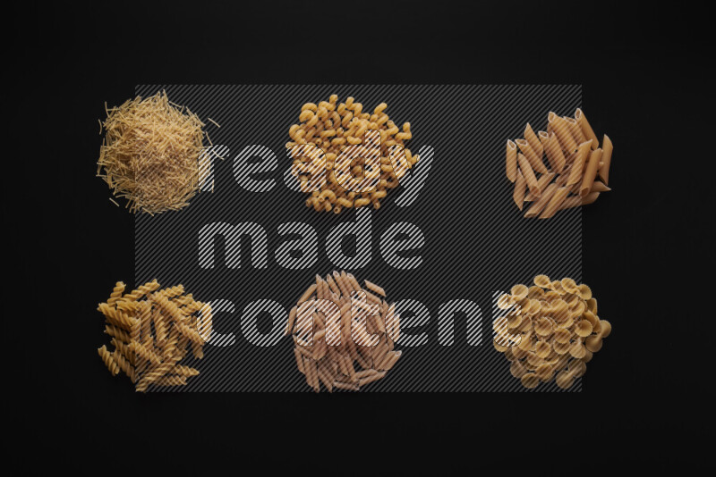 Different pasta types in bunches on black background