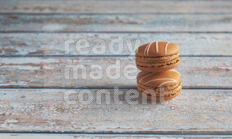 45º Shot of two Brown Irish Cream macarons on a  light blue wooden background