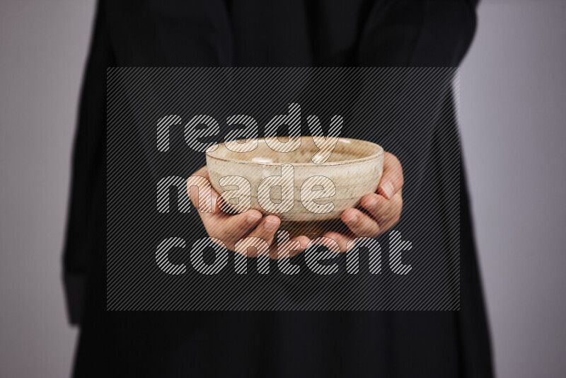 A woman in black abaya holding different pottery essentials in different positions