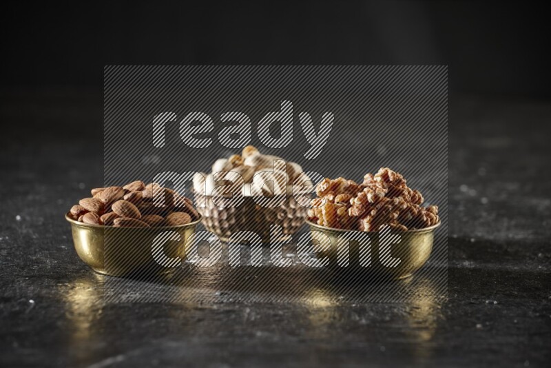 Nuts in a metal bowl in a dark setup