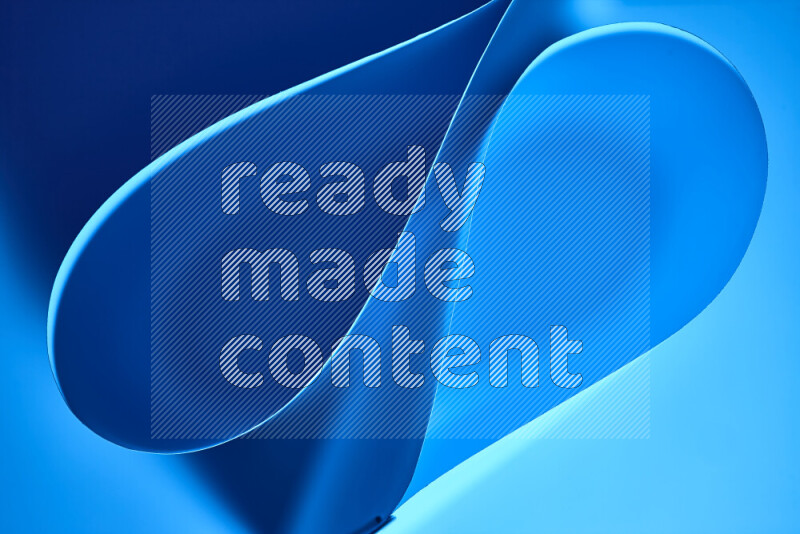 An abstract art of paper folded into smooth curves in blue gradients
