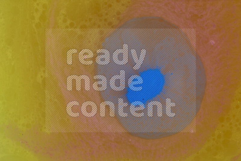 تلتقط الصورة تناثرا للطلاء الأزرق علي خلفية برتقالية