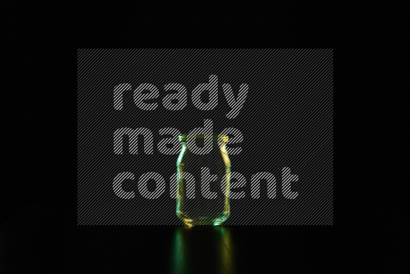 Glassware with rim light in green and yellow against black background