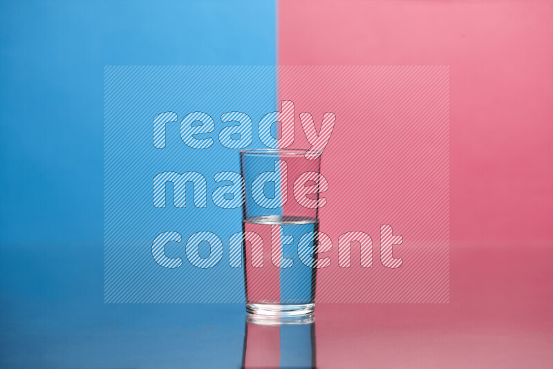 The image features a clear glassware filled with water, set against blue and pink background