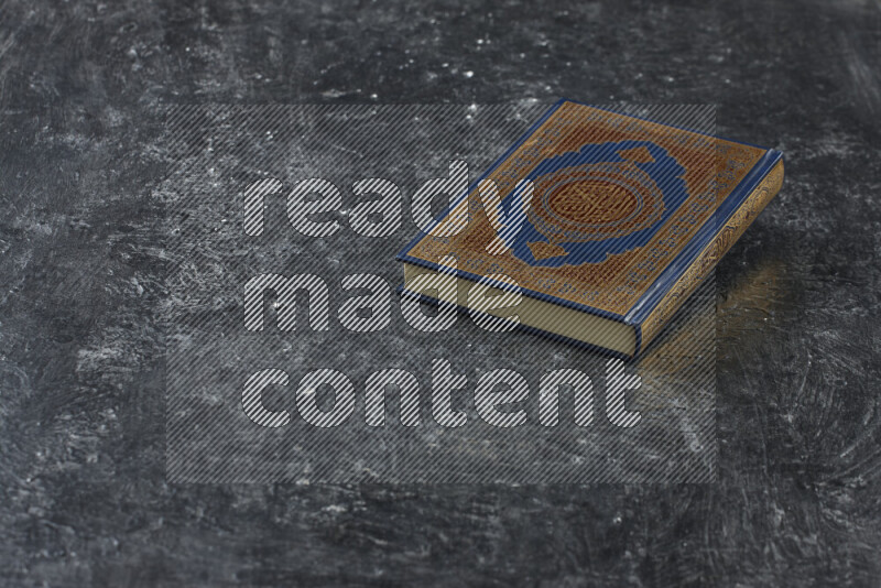 Quran with a prayer beads on textured black background