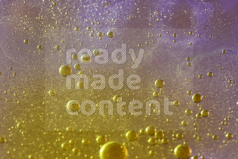 لقطات مقربة لقطرات ألوان مائية صفراء على سطح الزيت على خلفية وردية