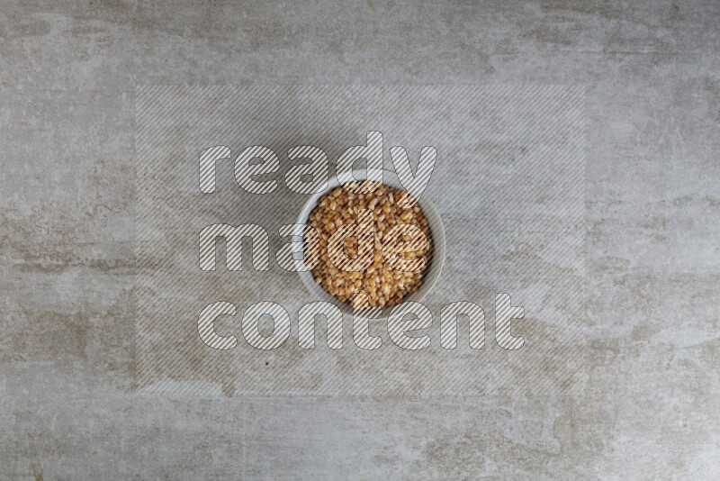 corn kernel in a gray ceramic bowl on a grey textured countertop