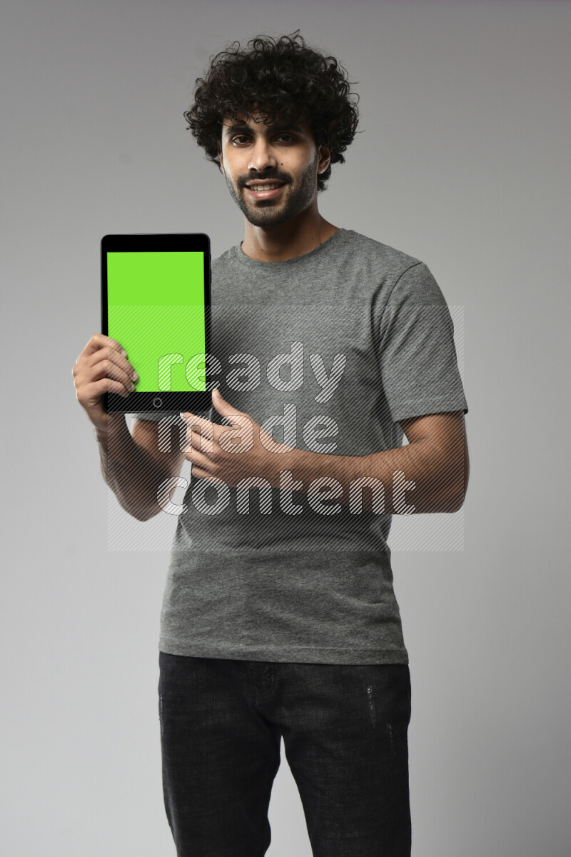 A man wearing casual standing and showing a tablet screen on white background