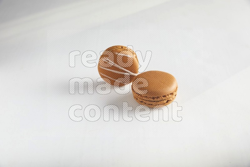 45º Shot of of two assorted Brown Irish Cream, and Brown Maple Taffy macarons  on white background