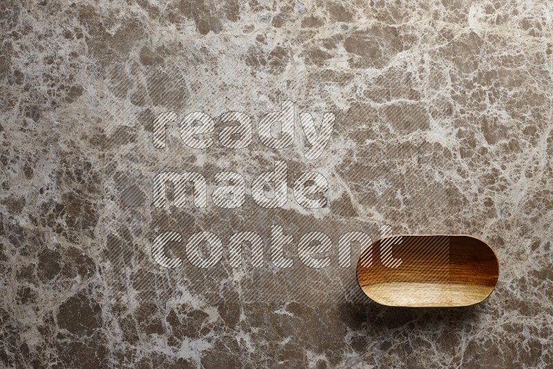 A wooden plate on beige marble background