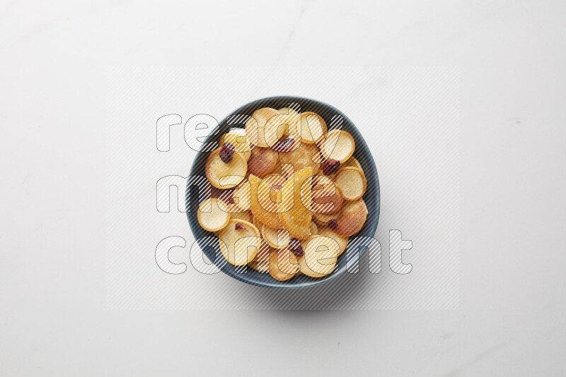Top-view shot of orange candy cereal pancakes in a round bowl on white background