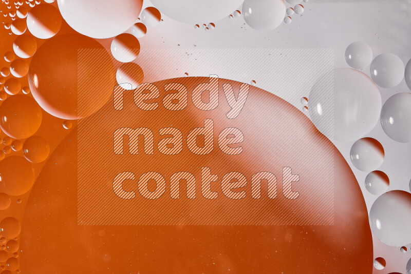 Close-ups of abstract oil bubbles on water surface in shades of white and orange