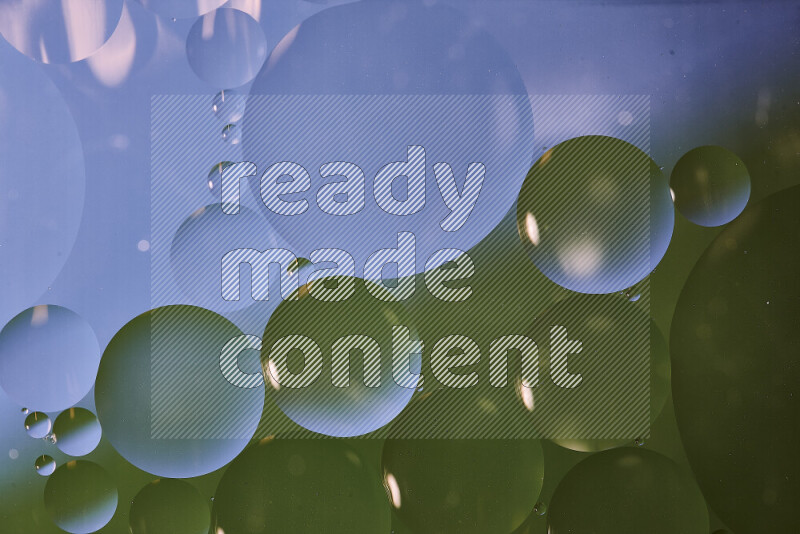 لقطات مقربة لفقاعات من الزيت على سطح الماء باللون الأزرق والأخضر