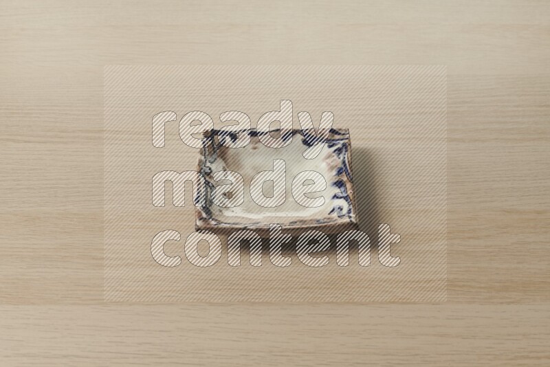 صحن فخاري مزخرف على خلفية خشبية فاتحة