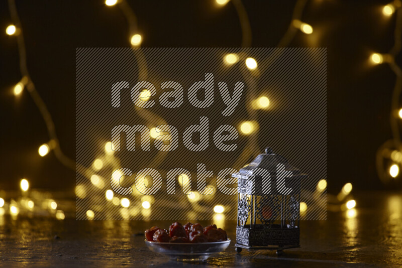 A traditional ramadan lantern surrounded by glowing fairy lights in a dark setup