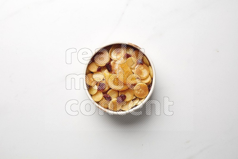 Top-view shot of orange candy cereal pancakes in a round bowl on white background